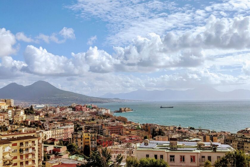 Panorama di Napoli vista dal mare con edifici storici e cielo azzurro