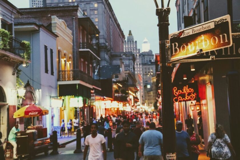 Scorcio serale del French Quarter di New Orleans con luci e passanti