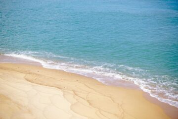 Spiaggia di Hainan con sabbia bianca, palme e mare cristallino