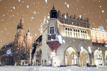 Veduta invernale di Cracovia con la Basilica di Santa Maria e la piazza principale coperte di neve