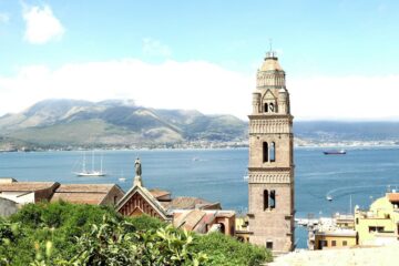 Panorama di Gaeta con il borgo medievale e il mare cristallino al tramonto.