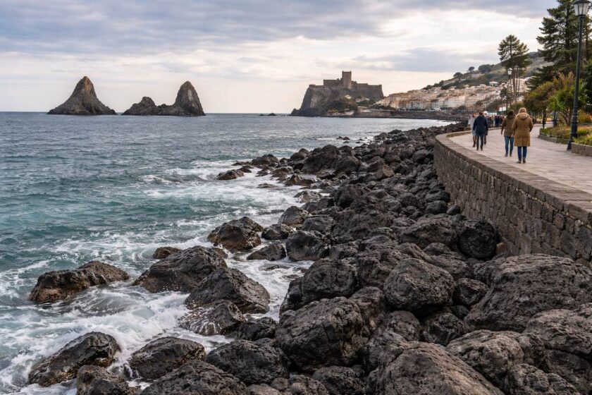 Mare invernale e costa lavica con faraglioni o castello nei dintorni di Catania