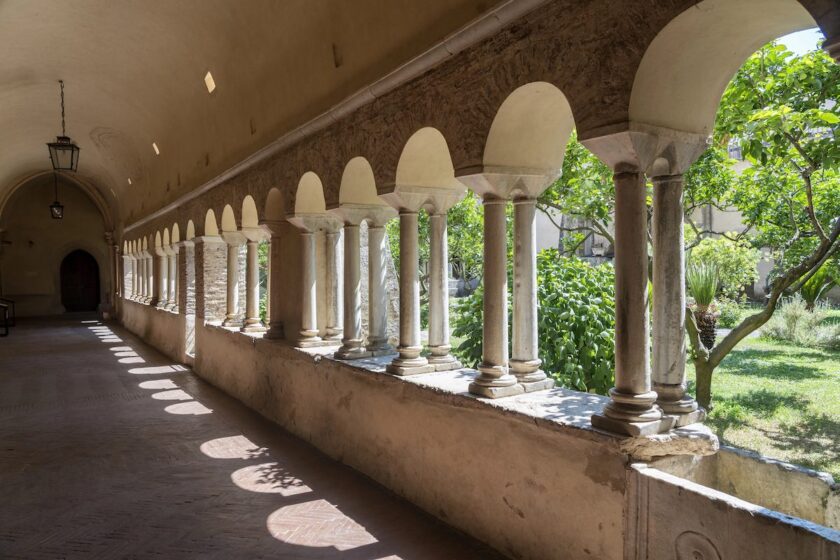 Chiostro di abbazia nel Lazio con archi in pietra e luce naturale