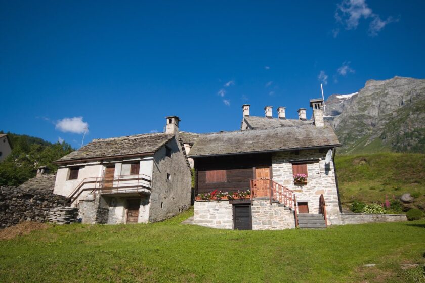 Borgo alpino nelle vallate piemontesi con case in pietra e paesaggio montano
