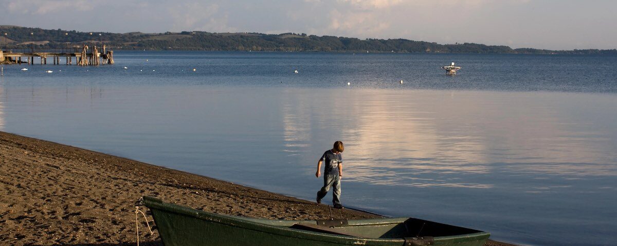 Spiaggia del Lago di Bracciano con acqua limpida e ciottoli
