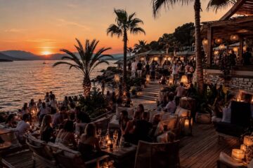 Beach club sulla costa croata al tramonto con giovani e mare sullo sfondo