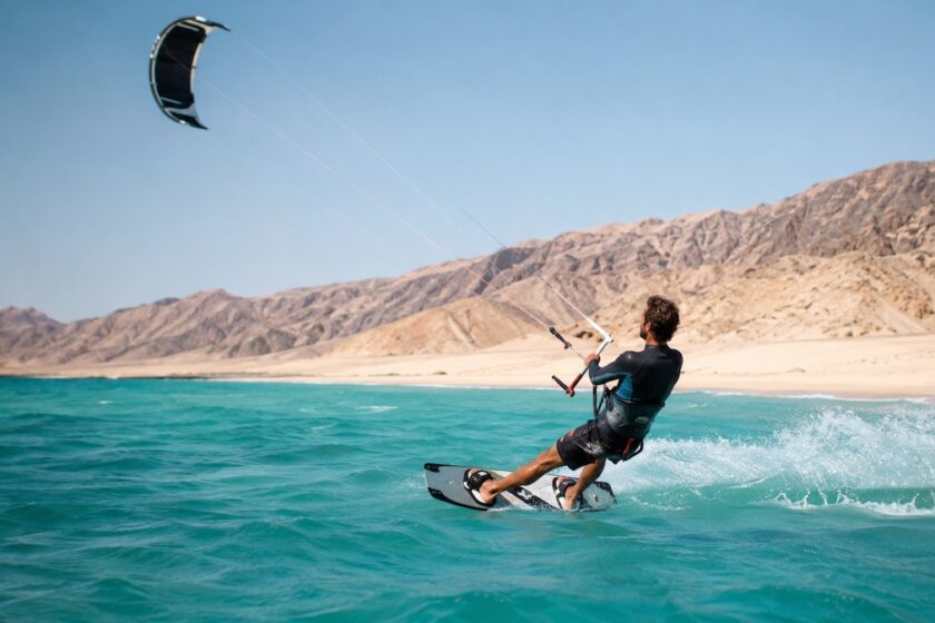 Kitesurfer sulla costa selvaggia dell’Oman tra mare turchese e deserto