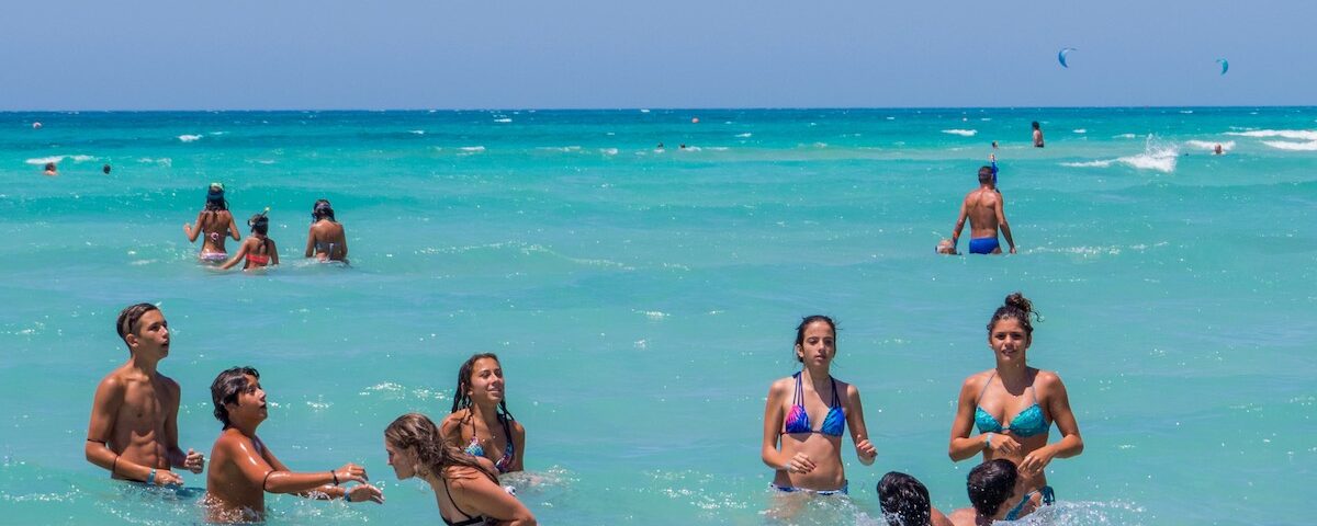 Giovani in spiaggia nel Salento con mare cristallino