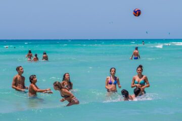 Giovani in spiaggia nel Salento con mare cristallino