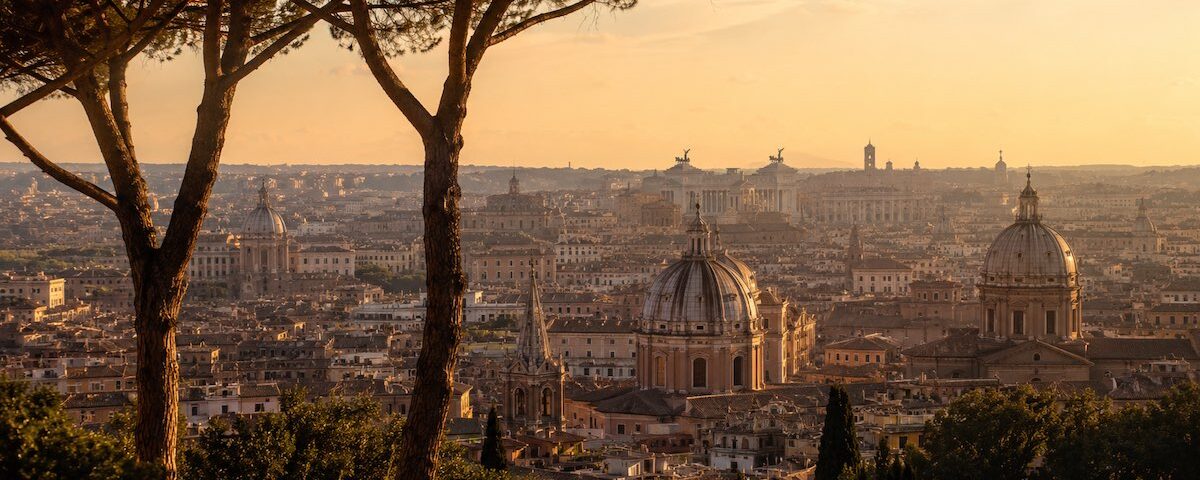 Panorama di Roma visto da uno dei sette colli con cupole, tetti storici e pini marittimi