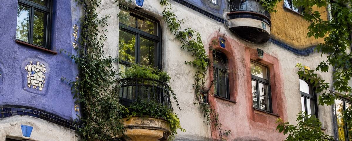 Dettaglio colorato dell’Hundertwasserhaus a Vienna con linee curve, finestre irregolari e decorazioni artistiche